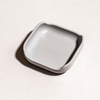 Close-up view of the gray Brick Mount accessory resting empty on a plain background.