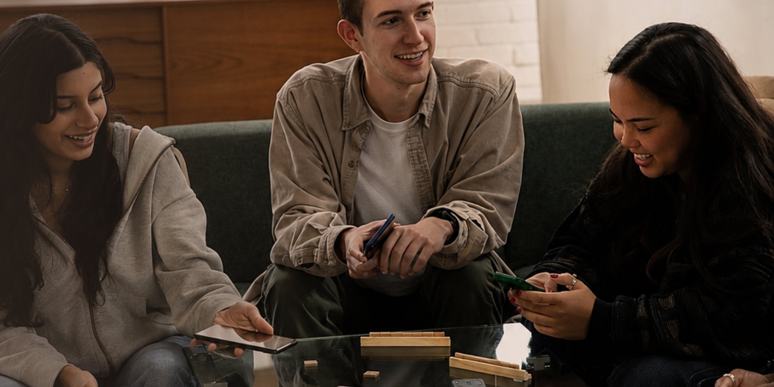 Three people sitting on a couch, engaged in a conversation.